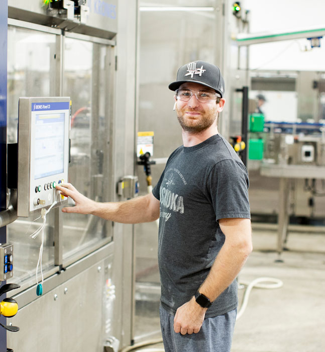 Person operating computer on canning line.