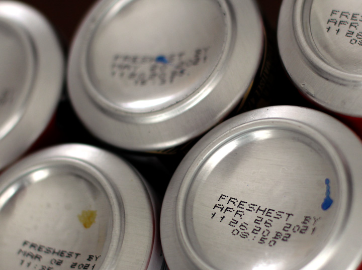 Tall cans, bottoms up to display freshness code placement.