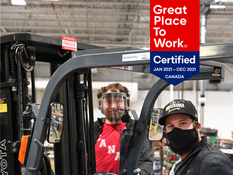 Two people around a fork lift with Great Place to Work Certification Badge in top right corner.