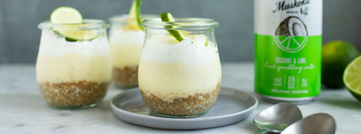 Desserts in glasses, topped with lime. Can of hard sparkling water, spoons.