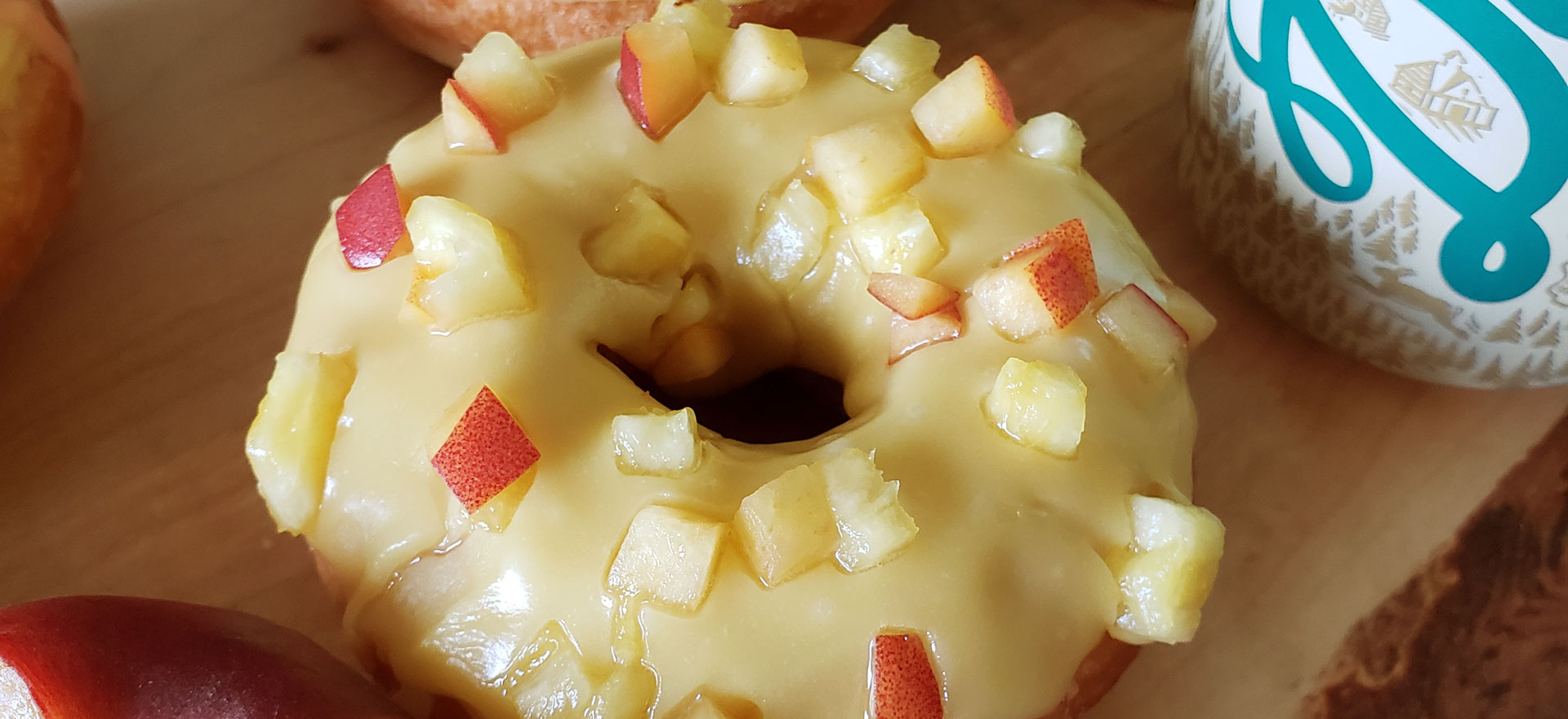 Close up of a donut topped with peach and pineapple